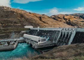 Powerful hydroelectric dam nestled in a rugged mountain landscape with clear blue waters.